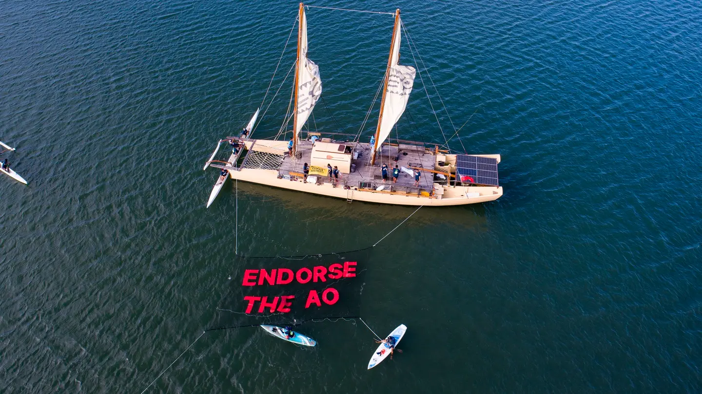 The action saw boats, canoes, and SUPs traverse the Fijian coastline, unfurling an over-water banner, with a chain of participants onshore and in the water joining with banners and chants calling on leaders to support the ICJ Advisory Opinion (AO).