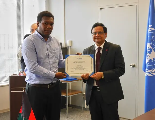 Graeme Risoni receives his certificate of completion from the UN SIAP Director, Ashish Kumar.