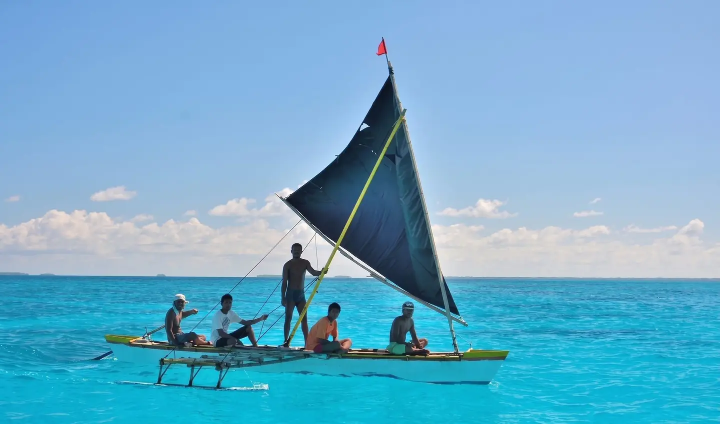 A sailing canoe with crew on the water in Kiribati.