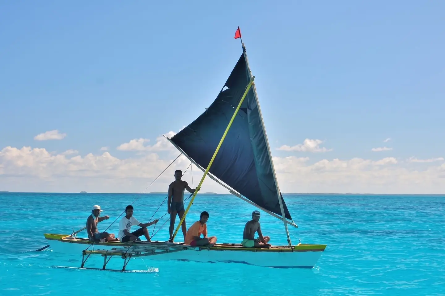 A sailing canoe with crew on the water in Kiribati.