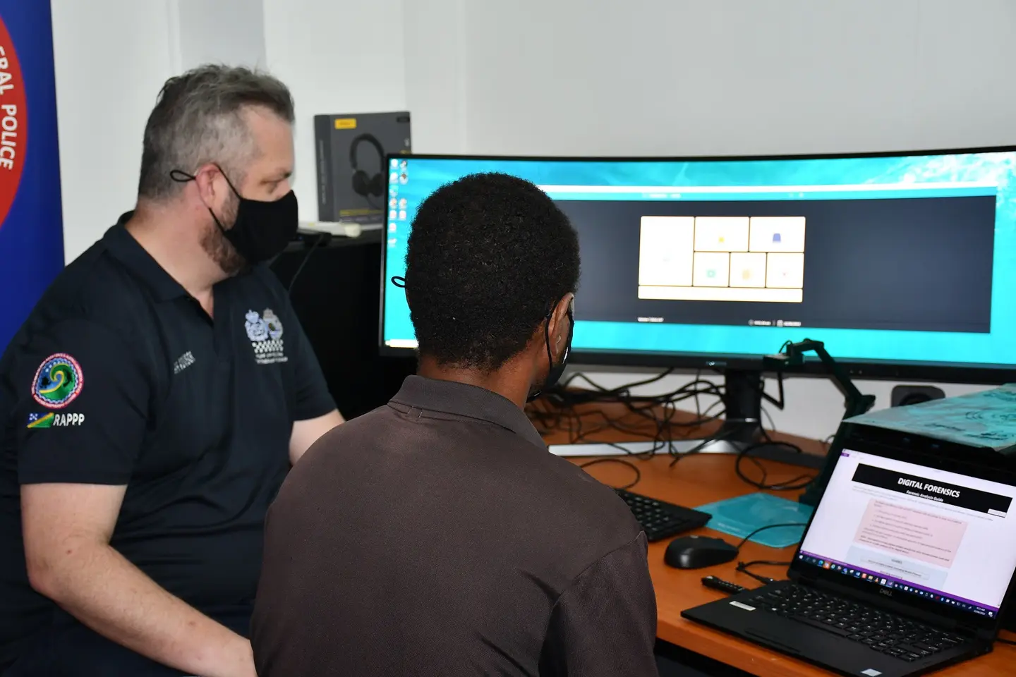 RSIPF member and AFP Advisor reviewing the new digital forensic capability.