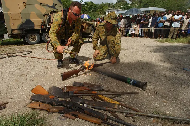 Members of RAMSI military destroy surrendered weapons, west Honiara, Solomon Islands, 2003.