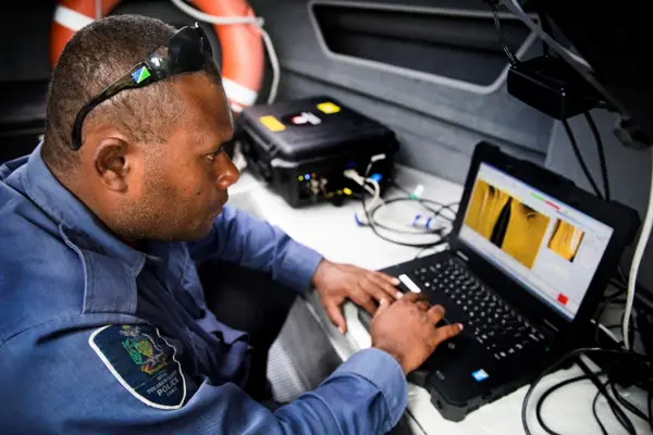 Royal Solomon Islands Police Force Constable Simon Rihia, of the Explosive Ordnance Team, monitors a towable side scan sonar array for an underwater search of explosive remnants of war in the Solomon Islands.