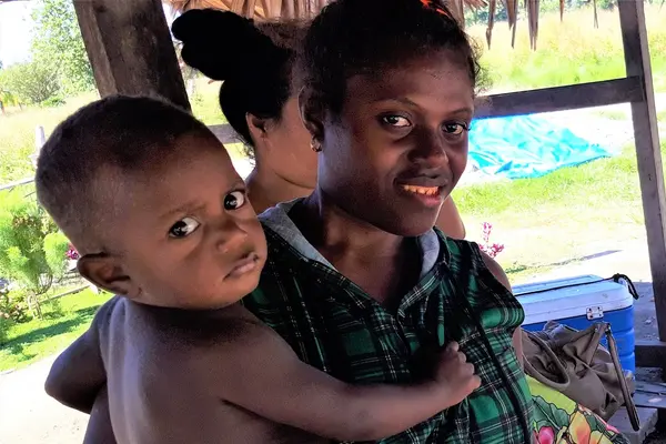 Lucy and her youngest child at their roadside stall in Aola.