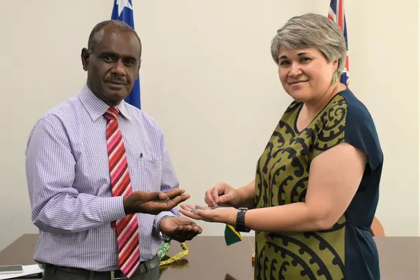 Hon. Minister Jeremiah Manele and High Commissioner Georgina Roberts stand with six pieces of pounamu to represent the quantum of fiscal relief being provided to Solomon Islands.