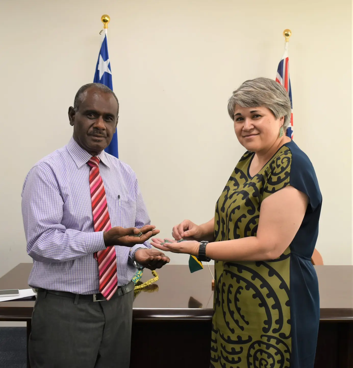 Hon. Minister Jeremiah Manele and High Commissioner Georgina Roberts stand with six pieces of pounamu to represent the quantum of fiscal relief being provided to Solomon Islands.