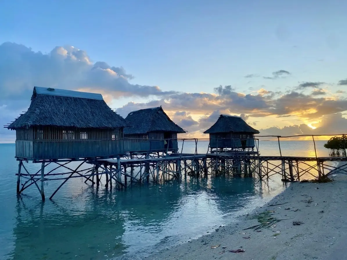 Traditional stilt structures on the water's edge in Kiribati, where communities face the frontline realities of sea-level rise and coastal change