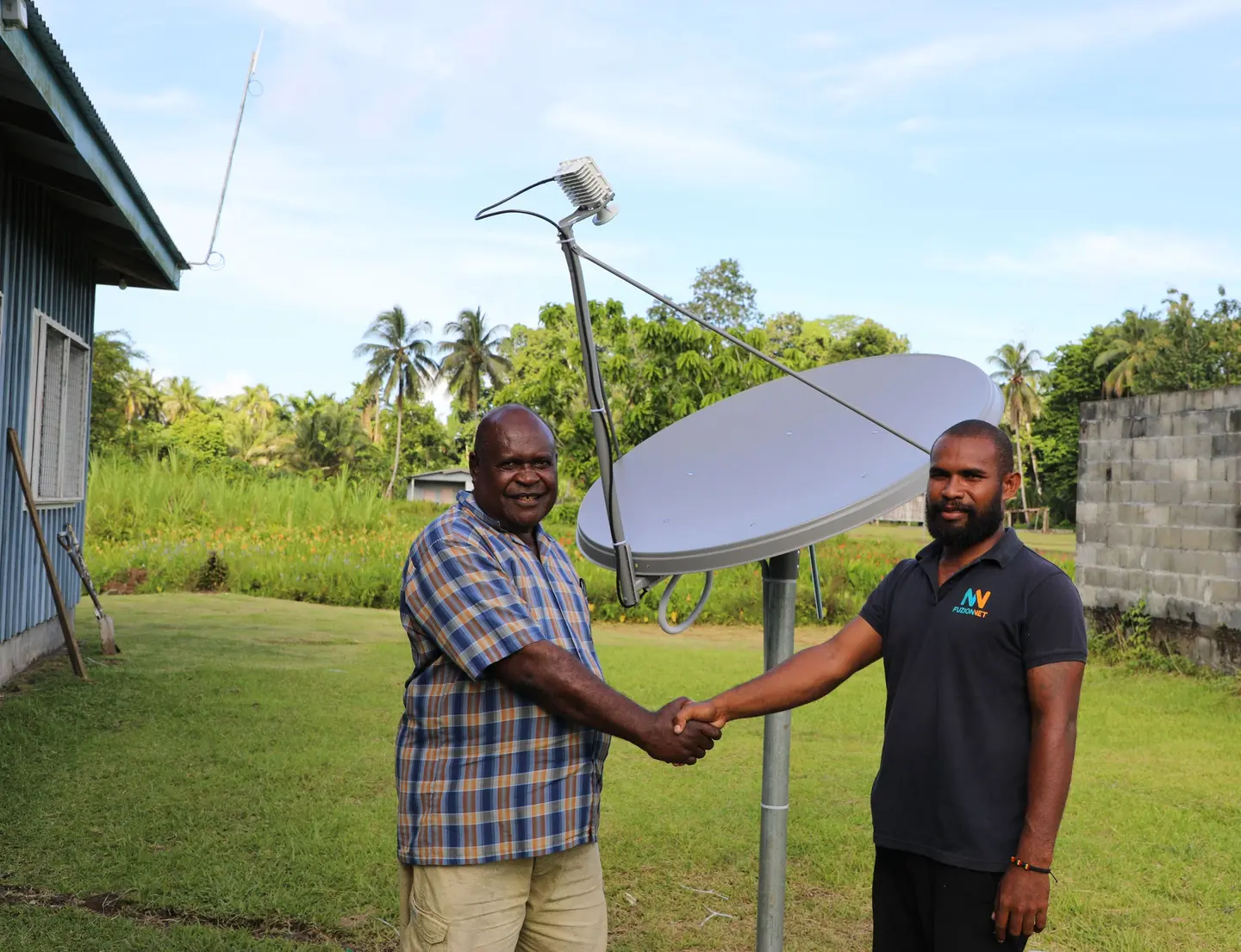 Constituency Development Officer (CDO) Collin Bemama Qalokisa shake hands with Alphie Nelson, field Engineer from Fuzionnet Company Ltd after the successful installation.
