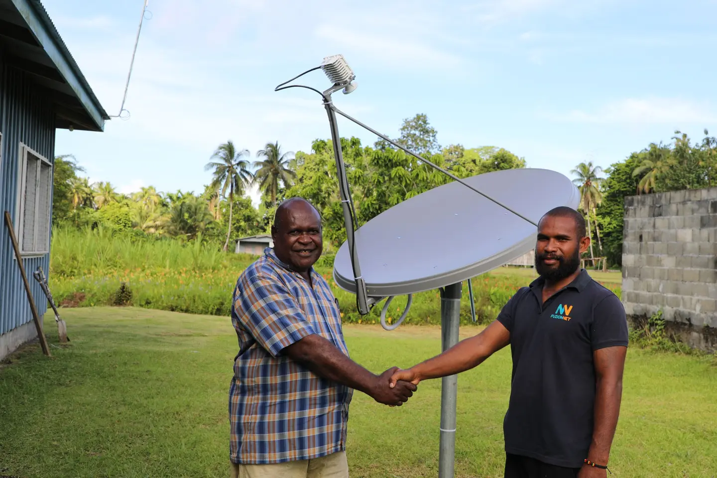 Constituency Development Officer (CDO) Collin Bemama Qalokisa shake hands with Alphie Nelson, field Engineer from Fuzionnet Company Ltd after the successful installation.