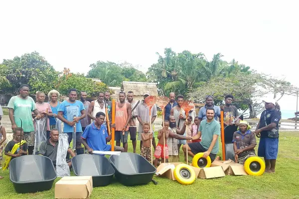 Far right National Healthy Settings Coordinator Mr. Ben Rickie and (second in front row) Dr. Edgar Pollard presented basic clean-up tools to Halavo community on behalf of Rotary Australia, WHO and MHMS.