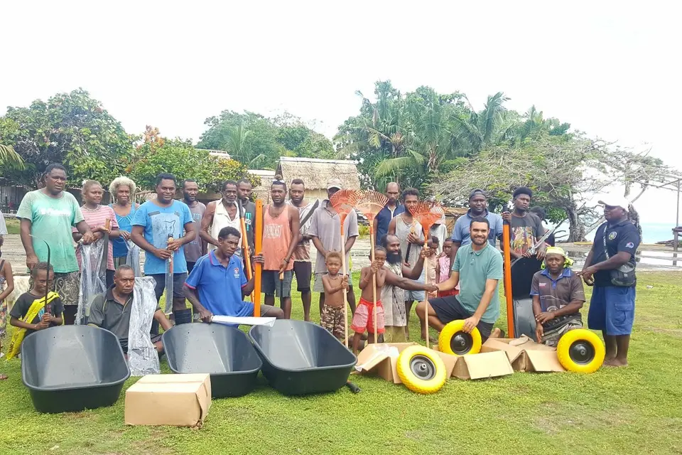 Far right National Healthy Settings Coordinator Mr. Ben Rickie and (second in front row) Dr. Edgar Pollard presented basic clean-up tools to Halavo community on behalf of Rotary Australia, WHO and MHMS.