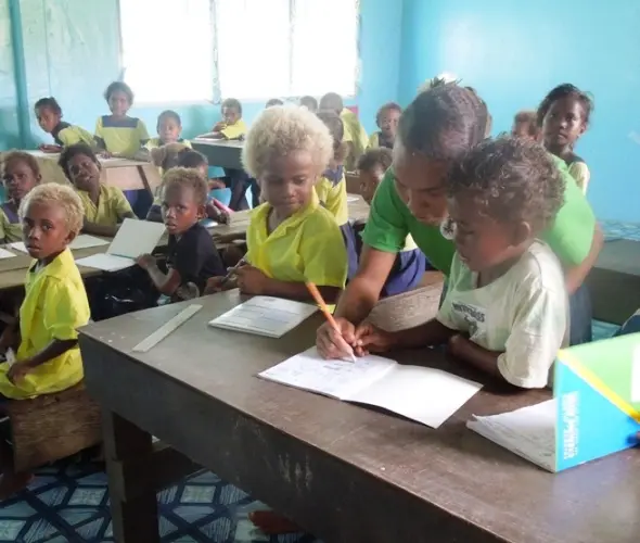 Little children of the Kilusakwalo Christian Community High School in their newly renovated classroom, thanks to their dedicated teachers and Jane Sheils, an Australian Volunteer.