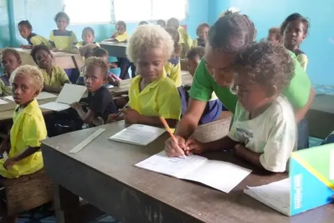 Little children of the Kilusakwalo Christian Community High School in their newly renovated classroom, thanks to their dedicated teachers and Jane Sheils, an Australian Volunteer.