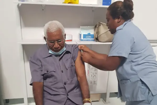 Governor General His Excellency Sir David Vunagi taking the vaccination.