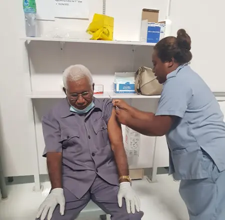 Governor General His Excellency Sir David Vunagi taking the vaccination.