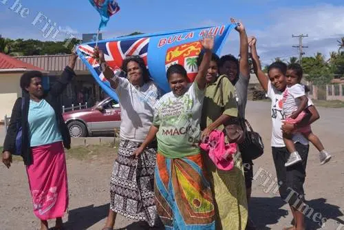 Semo villagers in Fiji on the roadside waiting to meet the country's rugby champs.