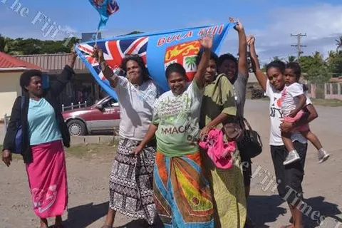 Semo villagers in Fiji on the roadside waiting to meet the country's rugby champs.