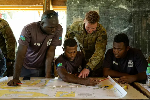 Private Brandon Stewart from 2nd Battalion, Royal Australian Regiment, teaches navigation theory to Royal Solomon Islands Police Force members.