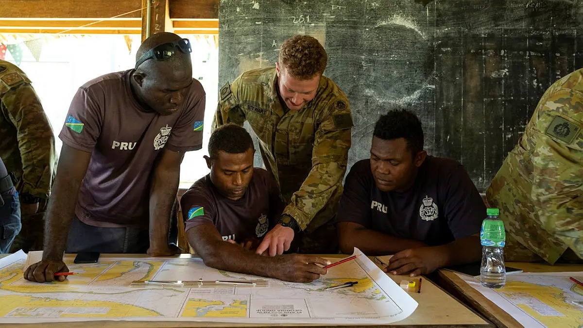 Private Brandon Stewart from 2nd Battalion, Royal Australian Regiment, teaches navigation theory to Royal Solomon Islands Police Force members.