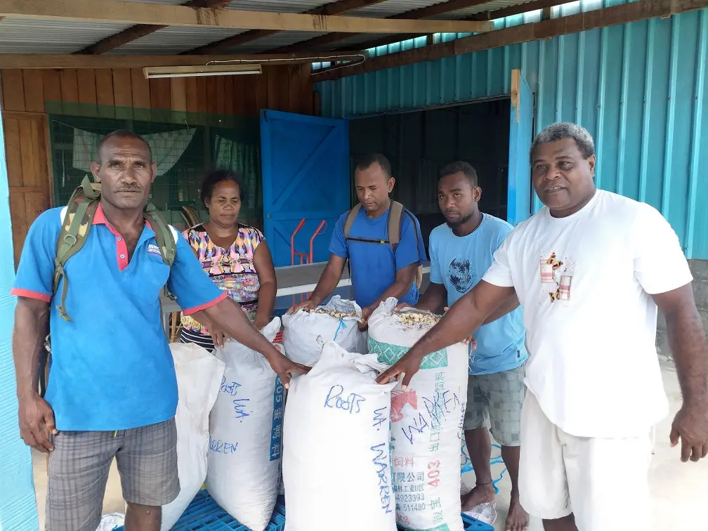 Mr. Warren Mane (L) with his Kava ready to be sold.