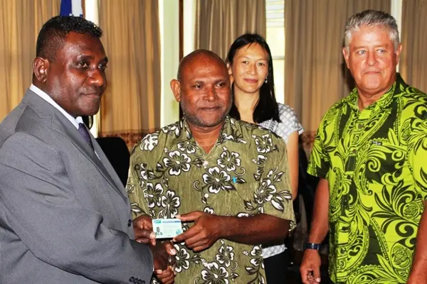 Prime Minister Gordon Darcy Lilo receiving his new licence from Deputy Principal Licensing Officer, George Tapo, accompanied by Acting New Zealand High Commissioner, Sarah Wong(back) and Commissioner of Inland Revenue, Mark Bell (right)
