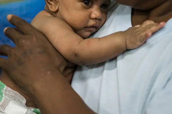 Elsie holding her 4 months-old daughter Elmah who has had diarrhoea for several days and waits to be attended by Doctors at Honiara Central Referral Hospital.