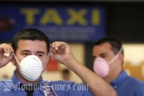 Airport workers put on surgical masks as they prepare to receive tourists arriving from Mexico at the Juan Santamaria International airport near San Jose, Monday, April 27, 2009.