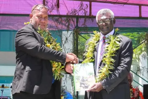 Prime Minister Manasseh Sogavare hands over the copy of the strategy (ASGSIP 2021-2030) to the Minister of Agriculture and Livestock Honourable Senley Levi Filualea.