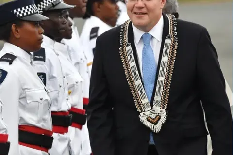 Australian Prime Minister Scott Morrison inspects a guard of honour by the Royal Solomon Islands Police Force after arriving at Honiara International Airport yesterday.