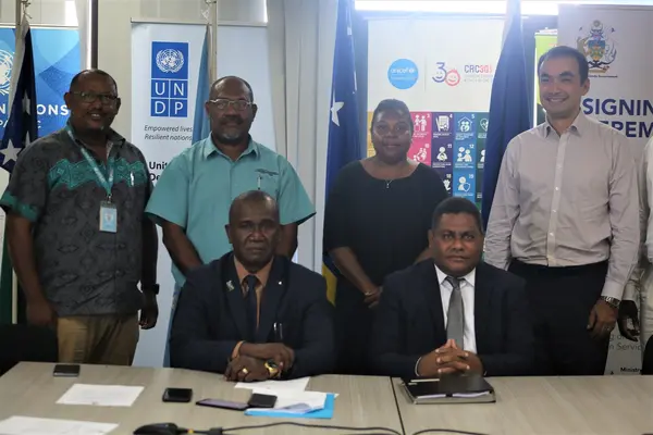 Hon. Seleso (L) and Hon. Ramofafia (R) with their Permanent Secretaries (standing centre) and representatives of the UN.