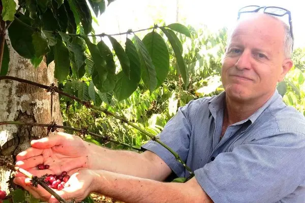 Jonathan Schwass holding coffee beans in Timor Leste.