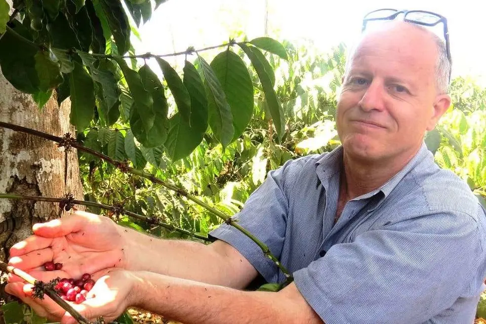 Jonathan Schwass holding coffee beans in Timor Leste.