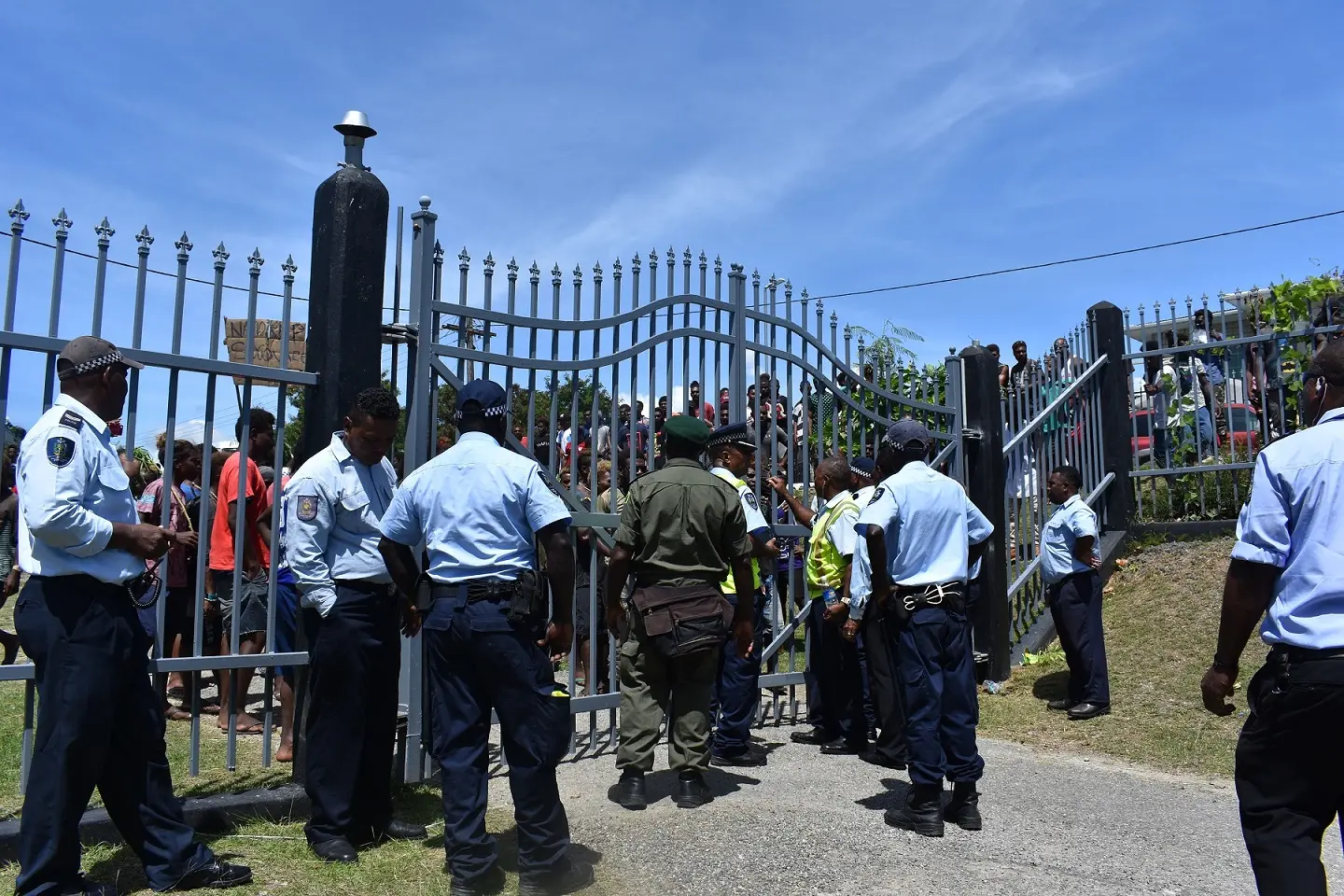 RSIPF officers, CSSI officers and Security officers talking to the crowd outside Parliament house yesterday.