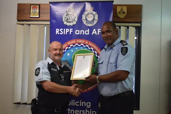 RSIPF Commissioner Mr Mostyn Mangau presents a certificate of appreciation and a RSIPF plaque as a token of appreciation to RAPPP Advisor James David Miller.