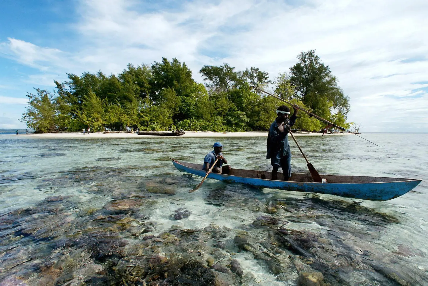 Fishermen paddle off Kennedy Island where Lt. John F. Kennedy and his PT-109 crew swam ashore after a Japanese ship sank their boat.