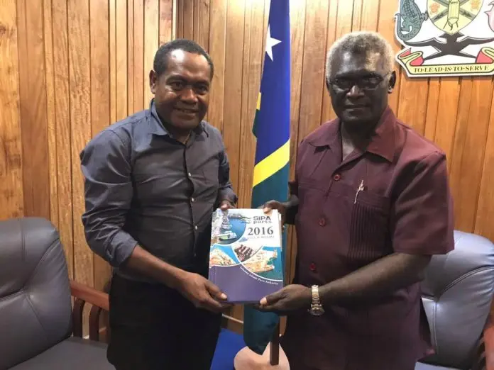 Chairman of SIPA Board, Mr Titiulu, left, handing over the Annual Reports for years 2011 - 2016 to Prime Minister Sogavare.