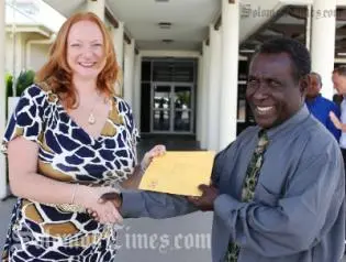 Acting Australian High Commissioner Alison Duncan receives a letter of support from the Minister for Agriculture and Livestock, Hon Connelly Sandakabatu for the PHAMA program.