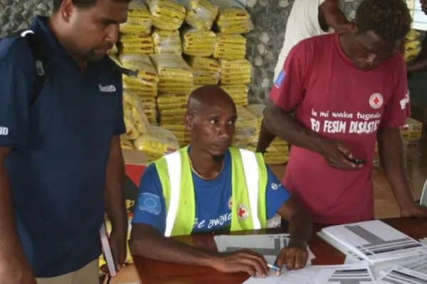 AusAID's rapid response officer, Eric Lui (L) and local authorities working out food distribution in Temotu Province.