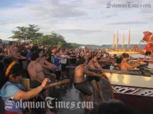 The New Zealand delegation pulls their Vaka ashore as the crowd looks on.