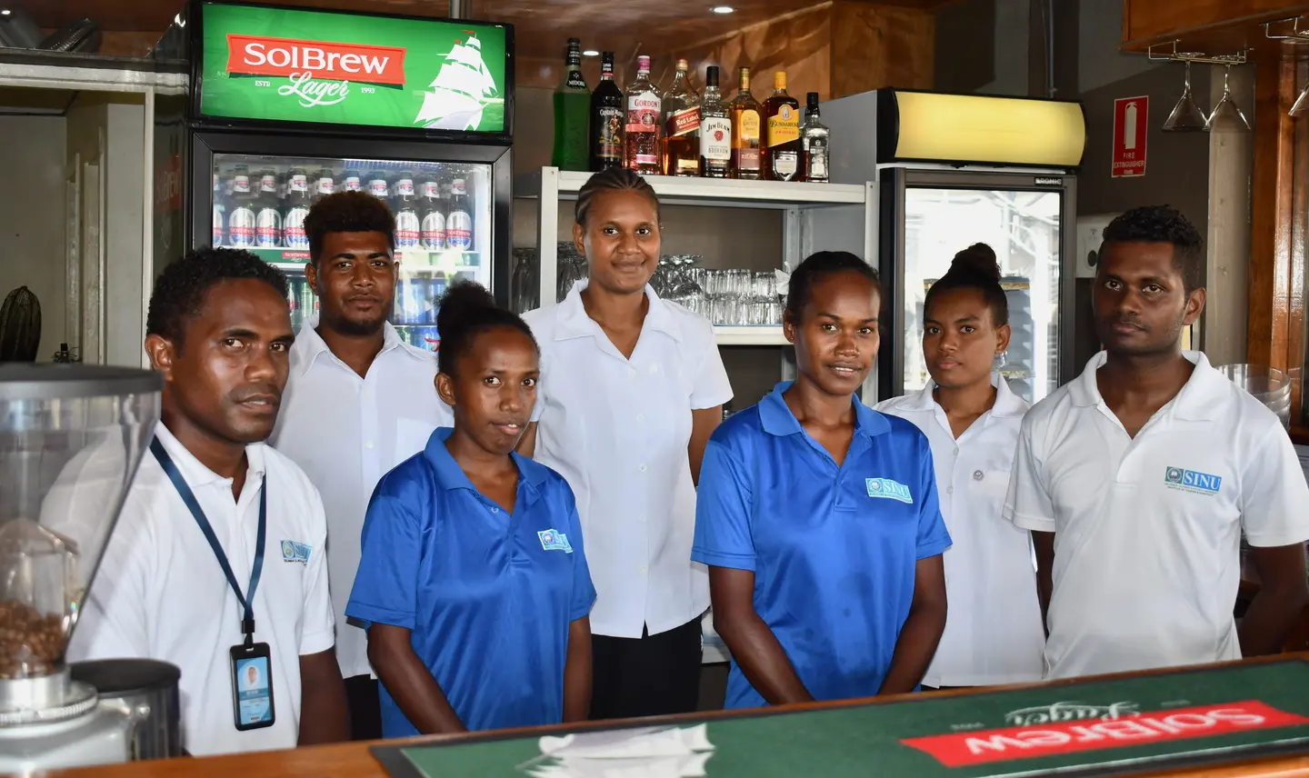 Tina River Hydro CBSP sponsored students, Rita Soloni and Emelda Bineth (in blue shirts) with their colleagues at the SINU-owned Lokol Fusion Café & Bar, where they are currently doing their internship.