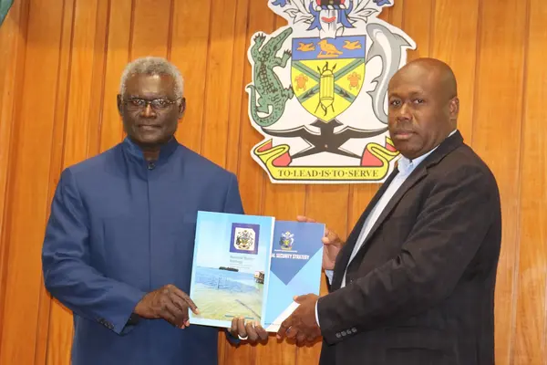 Minister for Police, National Security and Correctional Services Hon. Anthony Veke hands over the security strategy documents to the Prime Minister.