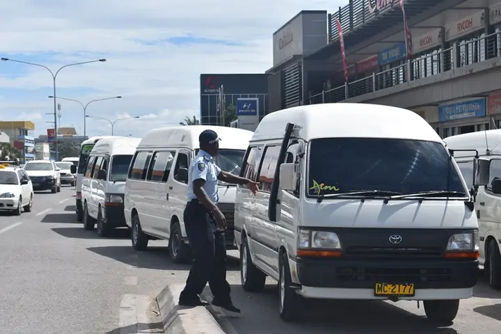 RSIPF traffic officers controlling traffic including buses at the Honiara Central Market bus stop.