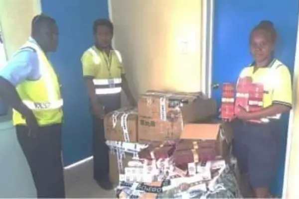 Customs Officers with the seized cigarettes.