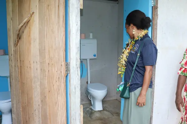 Mrs. Patricia Soqoilo, Chief Officer, Food Safety Unit, Environmental Health inspecting a lavatory facility at one of the household in Namoraoni Community.