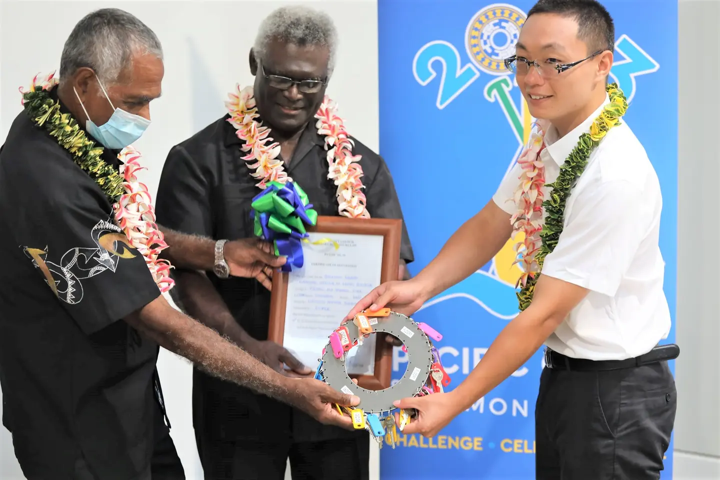 CCECC SINIS project Manager, Qi Rongbao, handing over the building keys and certificate to NHA Chair Dr Jimmie Rodgers and Prime Minister Manasseh Sogavare.