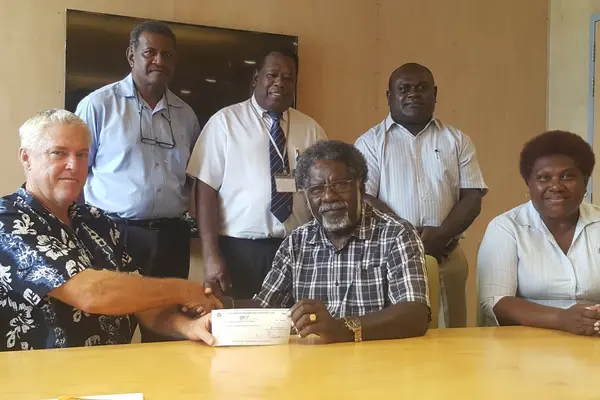 Chairman, SINPF Board, Mr Boyers, handing over a cheque of $120 million to Minister of Finance & Treasury, Hon Rini, in the presence of Ruth Alepio, SINPF Board Secretary (sitting). At the back, standing from left: General Manager (Acting) SINPF, Mike Wate, Governor CBSI, Denton Rarawa and Permanent Secretary Ministry of Finance, Harry Kuma.