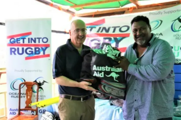 Australian High Commissioner Dr Lachlan Strahan handing over equipment to Solomon Island Rugby Union Federation President George Tema.