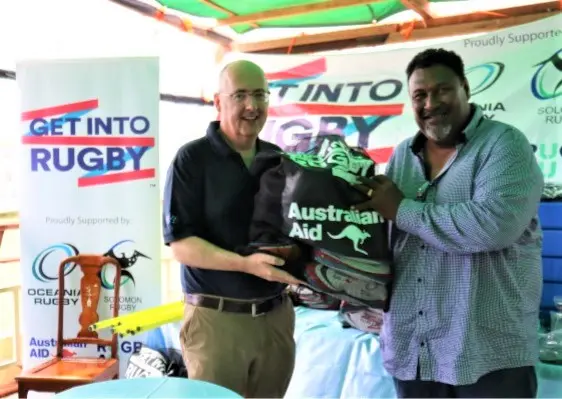Australian High Commissioner Dr Lachlan Strahan handing over equipment to Solomon Island Rugby Union Federation President George Tema.