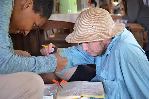 Aronson and another student measure the head size of ants as part of a field research course in the Solomon Islands.