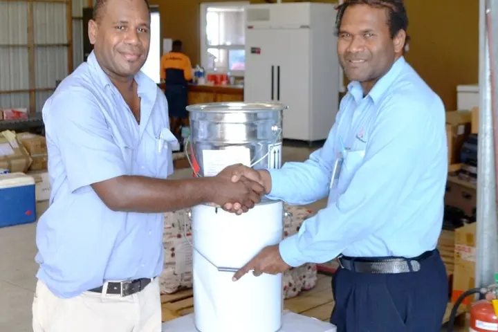 The buckets of paint were handed over to the President of the Rotary Club Sebastian Ilala (left).